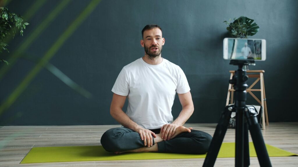 Man meditating in front of a phone camera